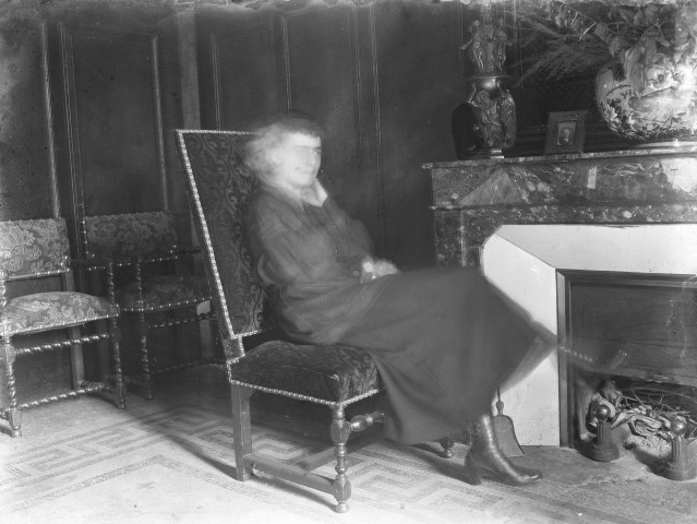 Charols, château de Salettes. - Marthe de Courtois, assise dans un fauteuil du salon, près de la cheminée.