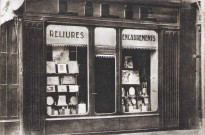 Vitrine de la boutique d’encadrements et reliures de M. Lilie, 4 place du Marché.