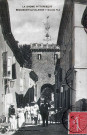 Beaumont-lès-Valence.- Personnages devant la porte fortifiée (XIIIe-XIVe s.) surmontée d'un campanile en fer forgé.