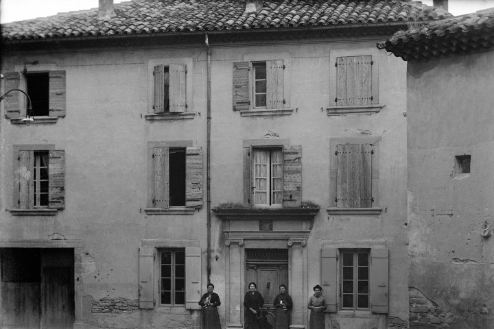 Façade d'une maison située place de l'église à Taulignan. Portrait de femme.