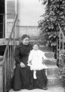 Montbard (Côte-d'Or). - Odette Cloup, assise sur les genoux de sa grand-mère sur les marches d'un perron.