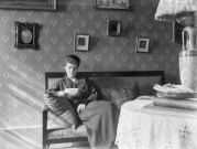 Charols, château de Salettes. - Marthe de Courtois lisant une lettre, assise dans le canapé du salon.