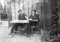 Montbard (Côte-d'Or). - Henri et Robert Bizalion, assis à une table de jardin, lisant.