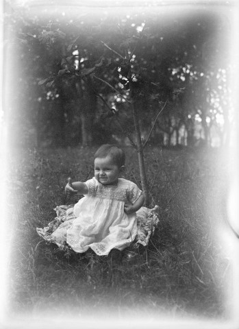 Charols, château de Salettes. - Marie-Thérèse Champin, assise dans le pré, à côté d'un arbre.