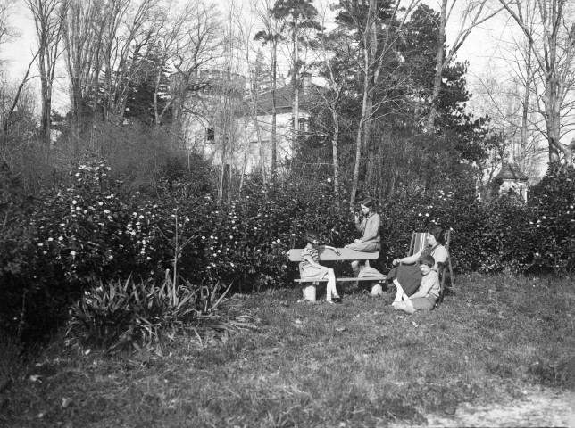 Charols, château de Salettes. - Françoise Champin, Marie-Thérèse Champin, assises sur un banc, Marthe de Courtois, assise dans une chilienne et Jacques Champin, assis dans l'herbe, au soleil.
