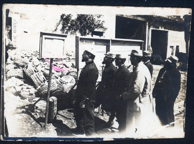 Soldats lisant des affiches.