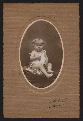 Petite fille assise sur un coussin.