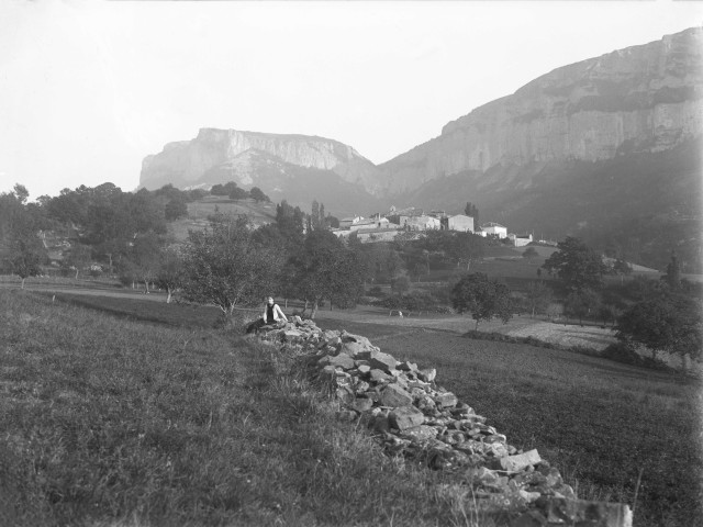Eyzahut. - Vue sur le village avec, au premier plan, Marthe de Courtois assise sur un amoncellement de pierres.
