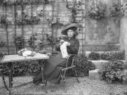 Montbard (Côte-d'Or). - Marie Champin brodant, assise à une table de jardin.