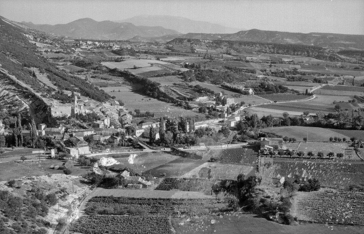 Le Pègue. - Vue aérienne du village au pied de la montagne de la Lance.