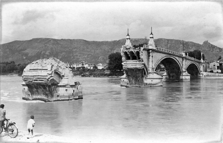 Le 20 juin 1940, le Génie français fait s'effondrer les deux arches du pont
de la rive gauche.